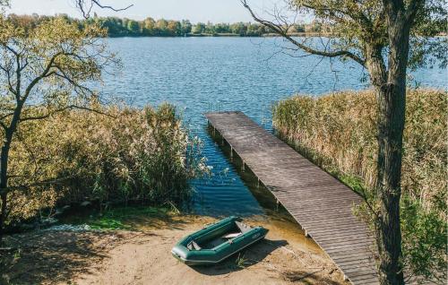 a green boat sitting on the shore of a lake at Beautiful Home In Ostrowite With Lake View in Ostrowite