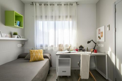 een kamer met een bank, een bureau en een raam bij Residencia Universitaria Barcelona Diagonal in Barcelona