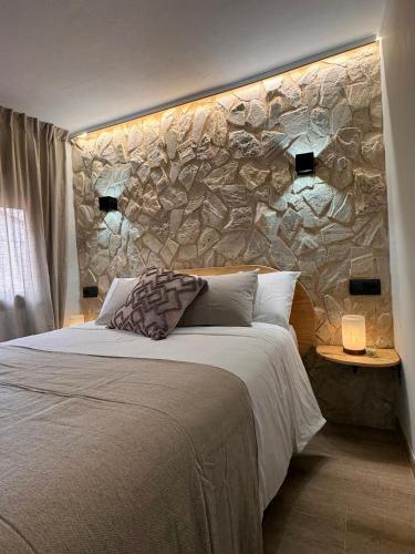 a bedroom with a stone wall next to a bed at La Rambla in Albarracín