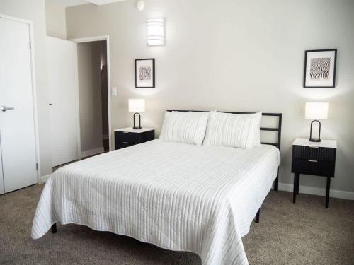 a bedroom with a large white bed with two night stands at Historic 2BR stay with patio & elevator in Indianapolis