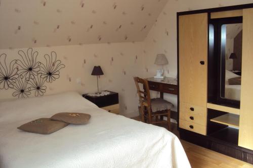 a bedroom with a white bed and a desk and a chair at le moulin à vent in Céré-la-Ronde