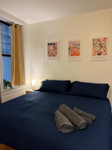 a bedroom with a blue bed with two towels on it at The Broadway Escape - Private Room in Times Square in New York