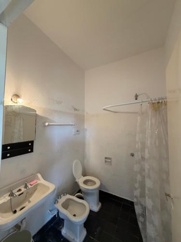 a bathroom with a toilet and a sink at Habitación con baño privado con cocina separada in Villa Cura Brochero