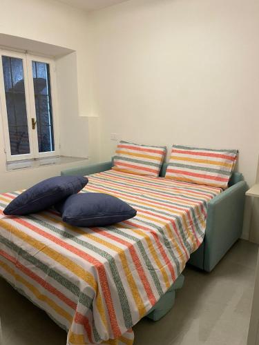 a bedroom with a bed with two pillows and a window at Oasi di pace in Domaso
