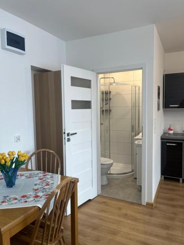 a dining room with a table and a bathroom at Studio pod Orzechem in Zbąszyń