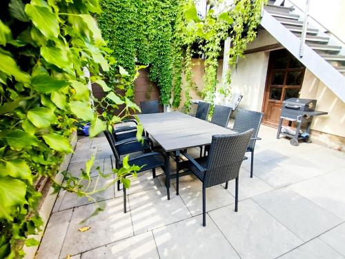 a table and chairs on a patio with ivy at Apartment Elli in Lichtenhain