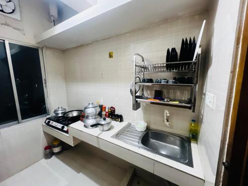 a small kitchen with a sink and a stove at Gulshan Guest House in Dhaka