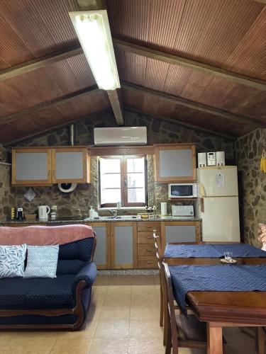 a kitchen and dining room with a table and chairs at Quinta Cabeço do Barragão in Fundão