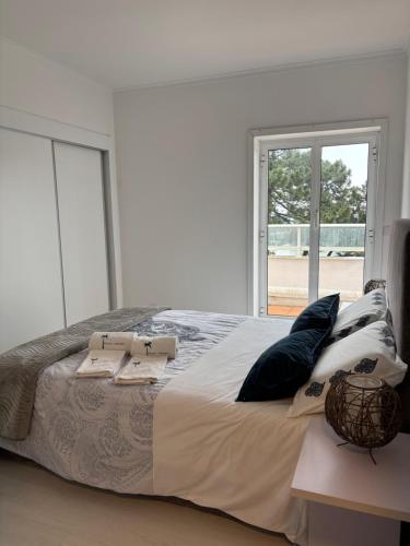 a bedroom with a large bed with pillows and a window at Beach House Cabedelo in Viana do Castelo
