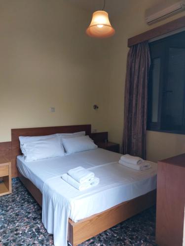 a bedroom with a bed with two towels on it at Elafonisos Rooms in Kefálion