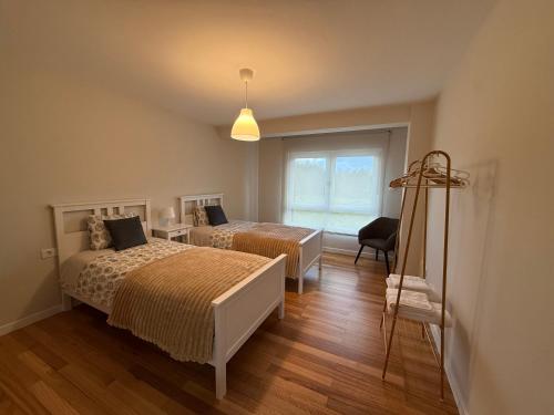 a bedroom with two beds and a window at Casa Pilar segundo in Sigüeiro