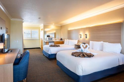 a hotel room with two beds and a television at Cayucos Beach Inn in Cayucos