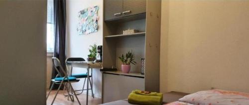 a bedroom with a bed and a desk and a table at Sleep&Coffee&Go in Trier