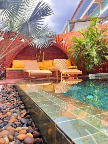 a patio with a pool and chairs and a building at Nine Hotel Chiangmai in Chiang Mai