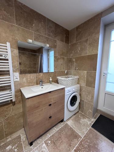 a bathroom with a washing machine and a sink at La parenthèse Jurassienne in Orgelet