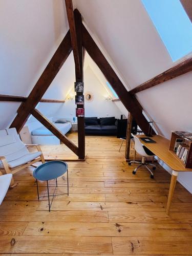 an attic room with a desk and a table at Le Jeanne d'Arc - Appartements meublés in Gien