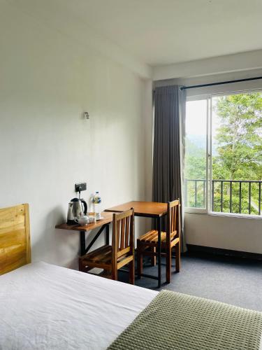 ein Schlafzimmer mit Schreibtisch, Tisch und Fenster in der Unterkunft Crystal Resort in Badulla