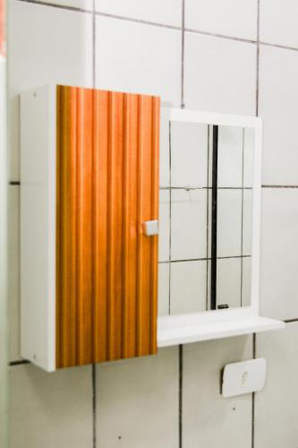 a cabinet with a mirror on a wall at Novo Maanaim Hotel in Presidente Epitácio