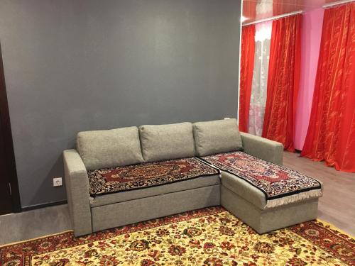 eine Couch in einem Wohnzimmer mit einem Teppich in der Unterkunft Apartments on pr. Lenina 7/42 in Montschegorsk