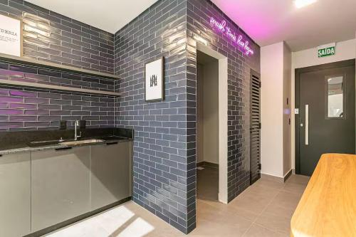 a bathroom with a sink and a blue tile wall at Loft Completo com Piscina Aquecida 250m da Vila Germânica in Blumenau