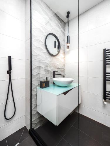 a bathroom with a sink and a glass shower at Прайм, централен апартамент in Pleven