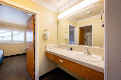 a bathroom with a sink and a mirror at Cayucos Beach Inn in Cayucos