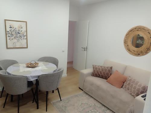 a living room with a table and a couch at Beach Blue Sesimbra in Sesimbra