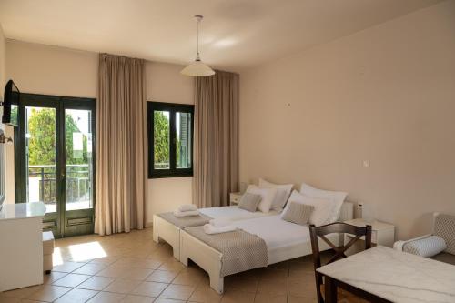 a bedroom with a bed and a couch and a table at So Nice Hotel in Marathokampos