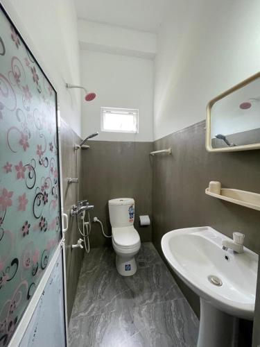 a small bathroom with a toilet and a sink at Emerald Coast Hotel Negombo in Negombo