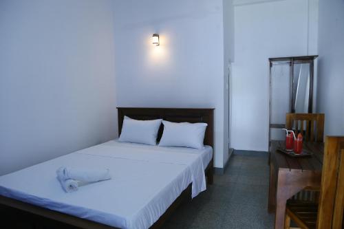 a bedroom with a bed and a desk and a bed sidx sidx sidx at Emerald Coast Hotel Negombo in Negombo