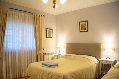 a bedroom with two beds and two lamps and a window at Arouca Passadiços Alojamentos & Jacuzzi - SPA in Arouca
