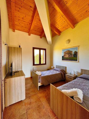 a bedroom with two beds and a wooden ceiling at Casa Micia Spilinga in Spilinga