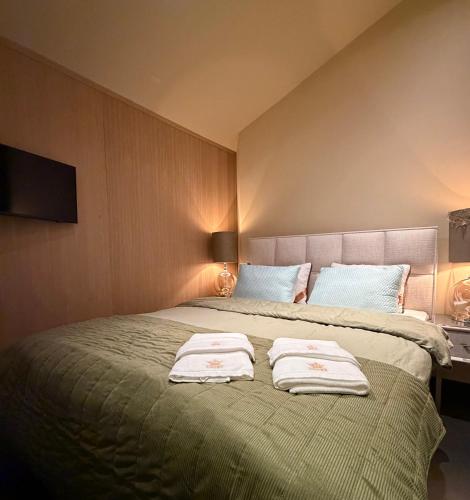 a bedroom with a large bed with towels on it at B & B De Allee in Almelo