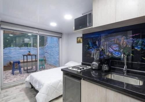 a kitchen with a sink and a bed in a room at Las Aguas Inner Experience in Bogotá