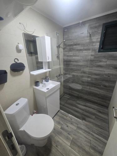 a bathroom with a white toilet and a shower at Sojenica Tamara in Ulcinj