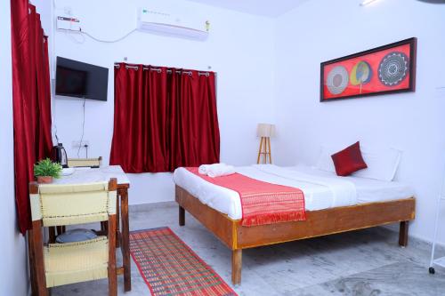 a bedroom with a bed and a red curtain at Garden bay in Pondicherry