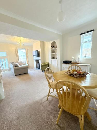 a kitchen and living room with a table and chairs at Beach Walk Cottage in Walton-on-the-Naze