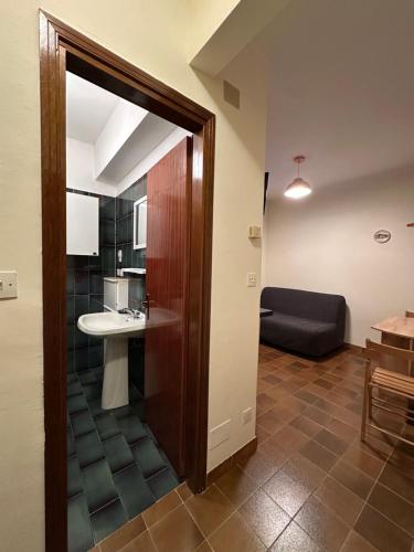 a room with a bathroom with a sink and a couch at Il mini rifugio di Pietro in Miroglio