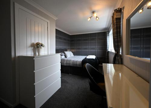 a bedroom with a bed and a dresser with a drawer at Marys view in Fort William