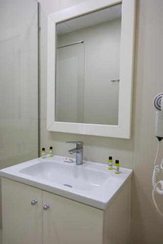 a bathroom with a white sink and a mirror at Hotel Adria in Shëngjin