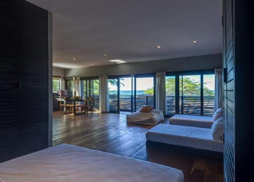 a living room with two beds and a view of the ocean at 99 Surf Lodge in El Limón