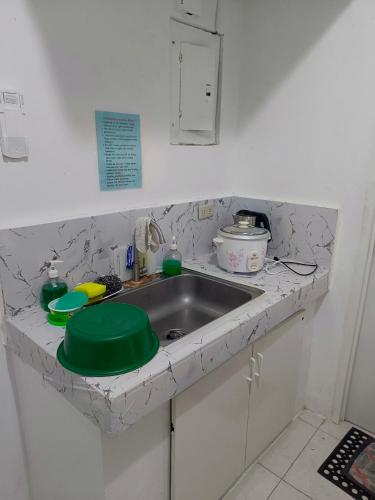 a kitchen counter with a sink with a green lid at Metro Capsule Rental in Manila