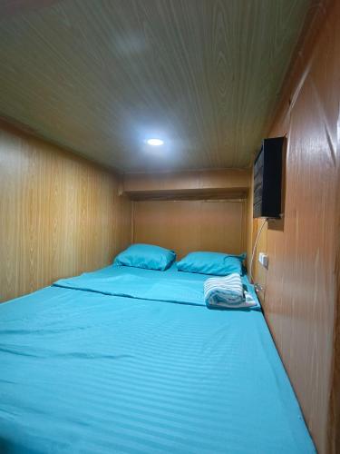 a bedroom with a bed with a tv on the wall at Metro Capsule Rental in Manila