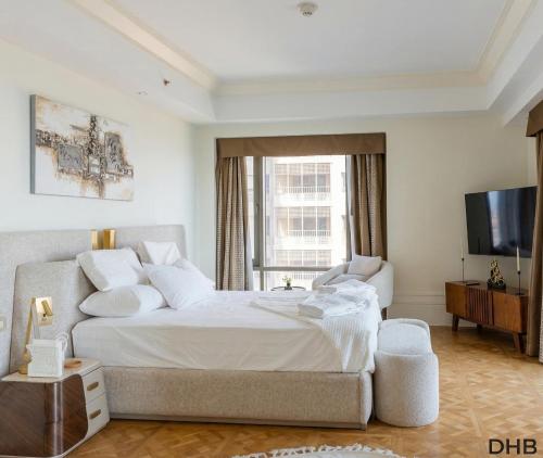 a bedroom with a large bed and a television at The St Regis Luxury in Cairo