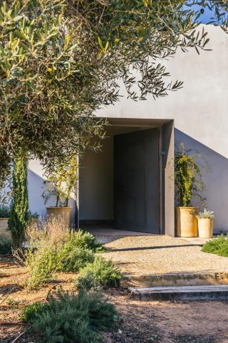 a building with a black door and some plants at Casa Torrenueva - Luxury Country House in Lebrija