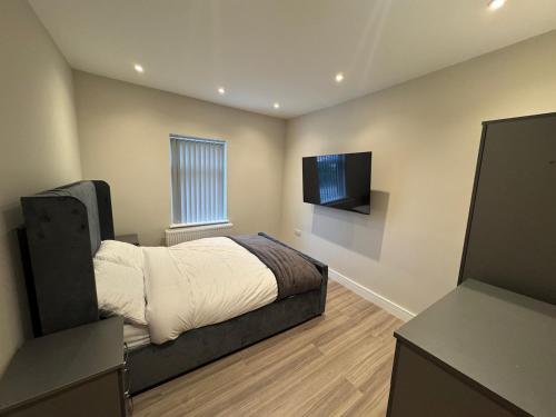 a bedroom with a bed and a flat screen tv at Brand New Luxury Centrally Located 2BR Apartment in Horninglow