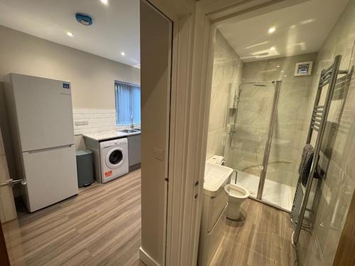 a bathroom with a shower and a washing machine at Brand New Luxury Centrally Located 2BR Apartment in Horninglow