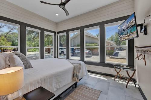 a bedroom with a bed and large windows at Historic Gem near Schlitterbahn in New Braunfels