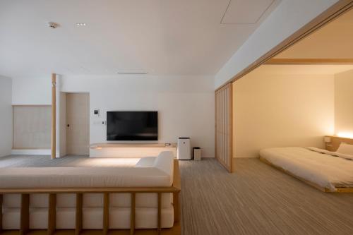 ein Schlafzimmer mit Bett und Flachbildfernseher in der Unterkunft JINRYU Hotel ISE in Ise