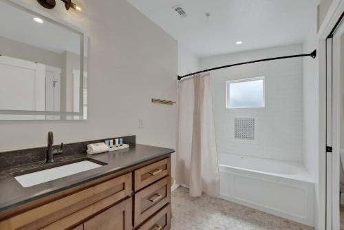 a bathroom with a sink and a shower with a mirror at The Grove Combo in Fredericksburg